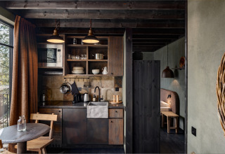 Gezellige keuken en eethoek in een houten hut bij Hillview Resort Grandvoir 1, België.