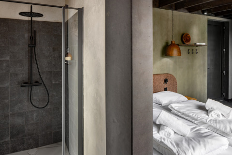 Moderne douche en knusse slaapkamer bij Hillview Resort Grandvoir 1, een blokhut in België.