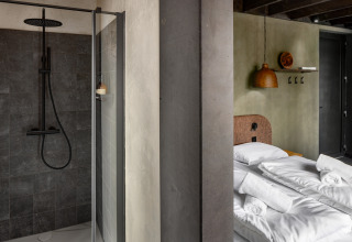 Moderne douche en knusse slaapkamer bij Hillview Resort Grandvoir 1, een blokhut in België.
