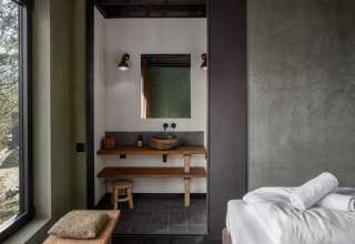 Modern cabine-interieur in Hillview Resort Grandvoir 1, België, met houten wastafel en minimalistisch ontwerp.