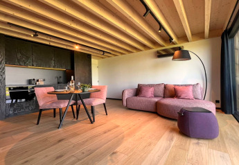 Salón moderno en la cabaña 'Natural Escape' en Bélgica, con techo de madera y sofá lila.