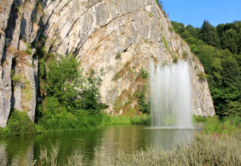 Una cascada tranquila cae en un lago junto a acantilados y árboles cerca de la cabaña 'Natural Escape' en Bélgica.