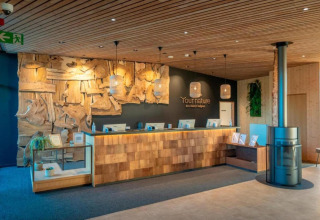 Reception con arredi in legno in un alloggio glamping, design eco-compatibile e atmosfera accogliente.