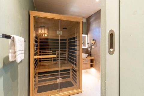 Modern infrared sauna and bathroom interior at The TreeLoft by YourNature, viewed through doorway.
