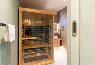 Modern infrared sauna and bathroom interior at The TreeLoft by YourNature, viewed through doorway.