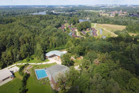 Aerial view of The TreeLoft by YourNature in Belgium, surrounded by forest, a pool, and nearby lodges.