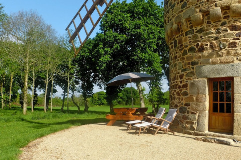Zona exterior en la casa de naturaleza 'Ancient windmill Gommenec'h' en Francia, con mesa y tumbonas.