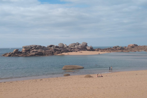 Spiaggia sabbiosa con rocce e mare presso Ancient windmill Gommenec'h, casa della natura in Francia.