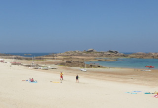 Una playa tranquila con pocas personas, veleros y rocas, cerca de Nature house Ancient windmill Gommenec'h en Francia.