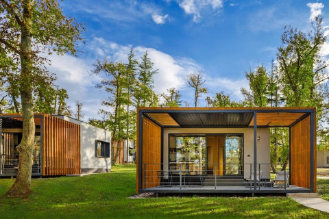 Moderne bungalow met houten accenten en terras tussen bomen bij Aminess Gaia Green Villas, Kroatië.