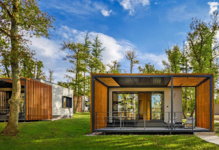 Moderne bungalow met houten accenten en terras tussen bomen bij Aminess Gaia Green Villas, Kroatië.