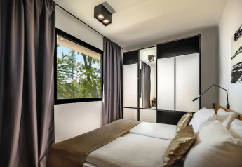Moderne soveværelse med dobbeltseng, spejlskab og stort vindue med udsigt, Aminess Gaia Green Villas, Kroatien.
