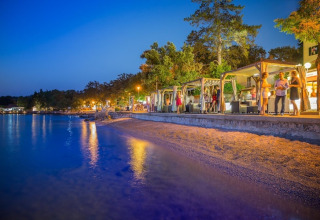 Avondsfeer bij Aminess Gaia Green Villas Njivice, Kroatië, waar gasten ontspannen aan het strand.