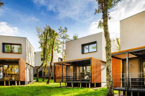 Moderne bungalow-villa’s met houten terrassen en grote ramen, omringd door natuur in Kroatië.
