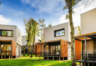 Moderne bungalow-villa’s met houten terrassen en grote ramen, omringd door natuur in Kroatië.