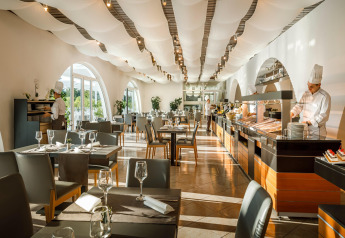 Moderne restaurant med buffet og kokke i Aminess Gaia Green Villas Njivice, Kroatien, solrig atmosfære.