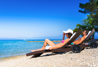 Stel ontspannen op ligbedden bij het strand van Aminess Gaia Green Villas Njivice in Kroatië.