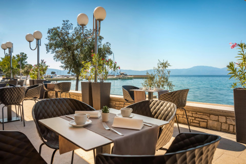 Terrazza all'aperto di Aminess Gaia Green Villas Njivice con vista sul mare e montagne in Croazia.