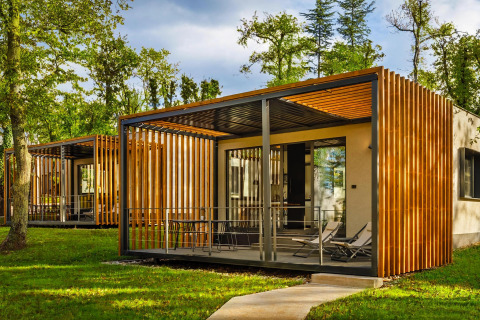 Modern mobiel huis bij Aminess Gaia Green Villas Njivice in Kroatië, omgeven door groen en zonlicht.
