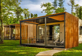 Modern mobiel huis bij Aminess Gaia Green Villas Njivice in Kroatië, omgeven door groen en zonlicht.