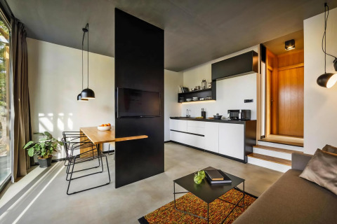 Modern mobielhuis interieur met open keuken, eethoek, bank en minimalistische inrichting in Kroatië.