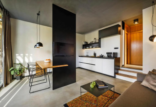 Interno di casa mobile moderna con cucina aperta, zona pranzo, divano e arredo minimalista in Croazia.