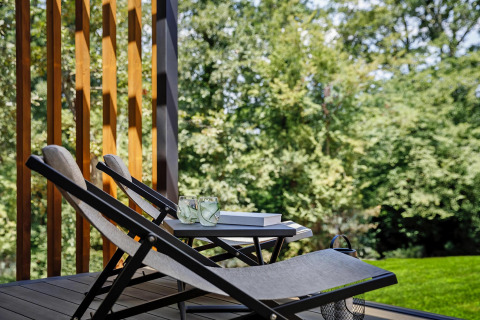 Terras met ligstoelen, drankjes en boeken, omgeven door groen bij Gaia Green Villas in Kroatië.
