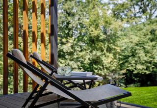 Terrazza con sdraio, bevande e libri, immersa nel verde alle Gaia Green Villas in Croazia.