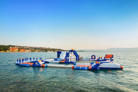 Opblaasbaar waterpark bij Aminess Gaia Green Villas Njivice in Kroatië, spelende kinderen in het water.
