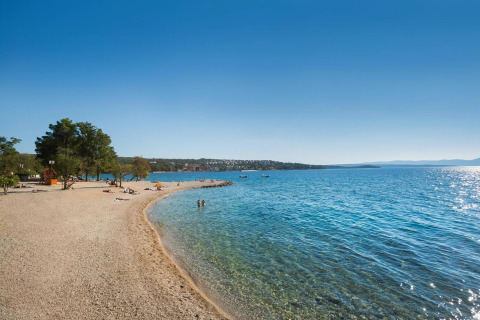 Spiaggia presso Aminess Gaia Green Villas Njivice in Croazia, con mare limpido e atmosfera rilassata.
