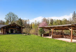 Chalet in legno e terrazza coperta immersi nel verde a Lomnice nad Popelkou, Repubblica Ceca, cielo sereno.