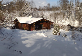 Chalet Lomnice nad Popelkou LLB005 in Repubblica Ceca circondato da neve e alberi in un paesaggio invernale.
