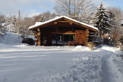 Chalet in legno immerso nella neve a Lomnice nad Popelkou LLB005, Repubblica Ceca, circondato da alberi.