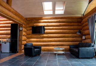 Soggiorno di uno chalet a Lomnice nad Popelkou, Repubblica Ceca, con divani in pelle e tavolo da scacchi.