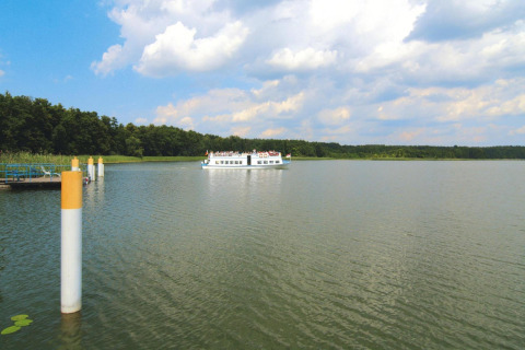 Zicht op een meer met een boot in de verte nabij Log cabin «30 m²» in Duitsland, omringd door natuur.