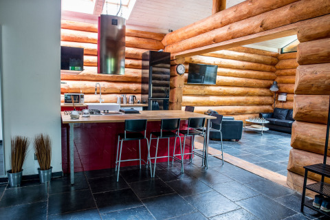 Cucina e soggiorno di chalet moderno con pavimento nero a Lomnice nad Popelkou, Repubblica Ceca.