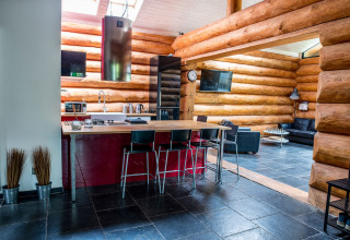 Cucina e soggiorno di chalet moderno con pavimento nero a Lomnice nad Popelkou, Repubblica Ceca.