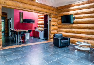 Soggiorno e cucina moderni nello chalet Lomnice nad Popelkou LLB005, Repubblica Ceca, con pareti in tronchi.
