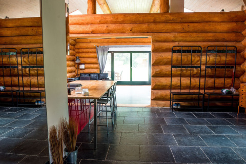 Interno di uno chalet rustico con tavolo da pranzo, letti a castello e pavimento in ardesia a Lomnice nad Popelkou.