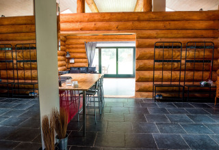 Interno di uno chalet rustico con tavolo da pranzo, letti a castello e pavimento in ardesia a Lomnice nad Popelkou.