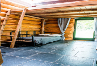 Interno dello chalet Lomnice nad Popelkou LLB005 in Repubblica Ceca con pareti di tronchi, letto e scala.