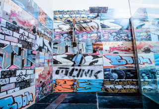 Parete decorata con graffiti colorati nello chalet 'Lomnice nad Popelkou LLB005' in Repubblica Ceca, stile urbano.