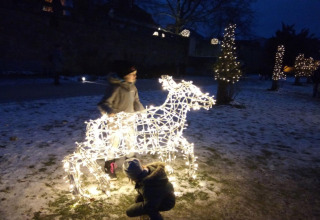 Bambini giocano con una decorazione di renna luminosa vicino allo chalet Lomnice nad Popelkou, Repubblica Ceca.