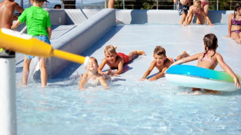 Bambini giocano nel parco acquatico del Trasimeno Glamping Resort, villaggio vacanze in Umbria, Italia.