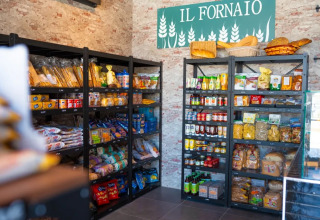 Scaffali con alimentari italiani e pane sotto l'insegna 'IL FORNAIO' al Trasimeno Glamping Resort.