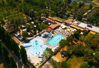 Vista aérea del Trasimeno Glamping Resort en Umbría, Italia, con piscinas, toboganes y zonas verdes alrededor.