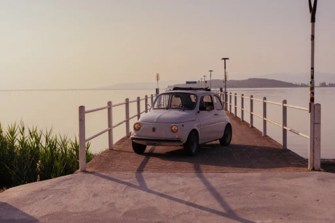 Un'auto d'epoca parcheggiata su un pontile sul lago vicino a Sant Arcangelo di Magione, Umbria, Italia.