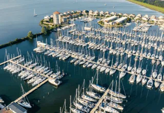 Luftfoto af Marina Parcs Lelystad i Holland med mange lystbåde og husbåde i havnen.