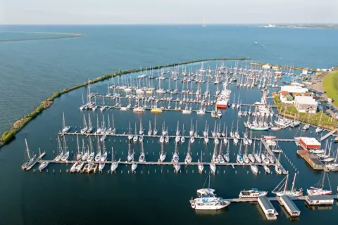 Luftaufnahme von Hausbooten und Yachten im Marina Parcs Lelystad mit Blick auf das Wasser in den Niederlanden.
