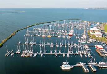 Vista aérea de casas flotantes y yates en Marina Parcs Lelystad, con paisaje acuático en Lelystad, Países Bajos.